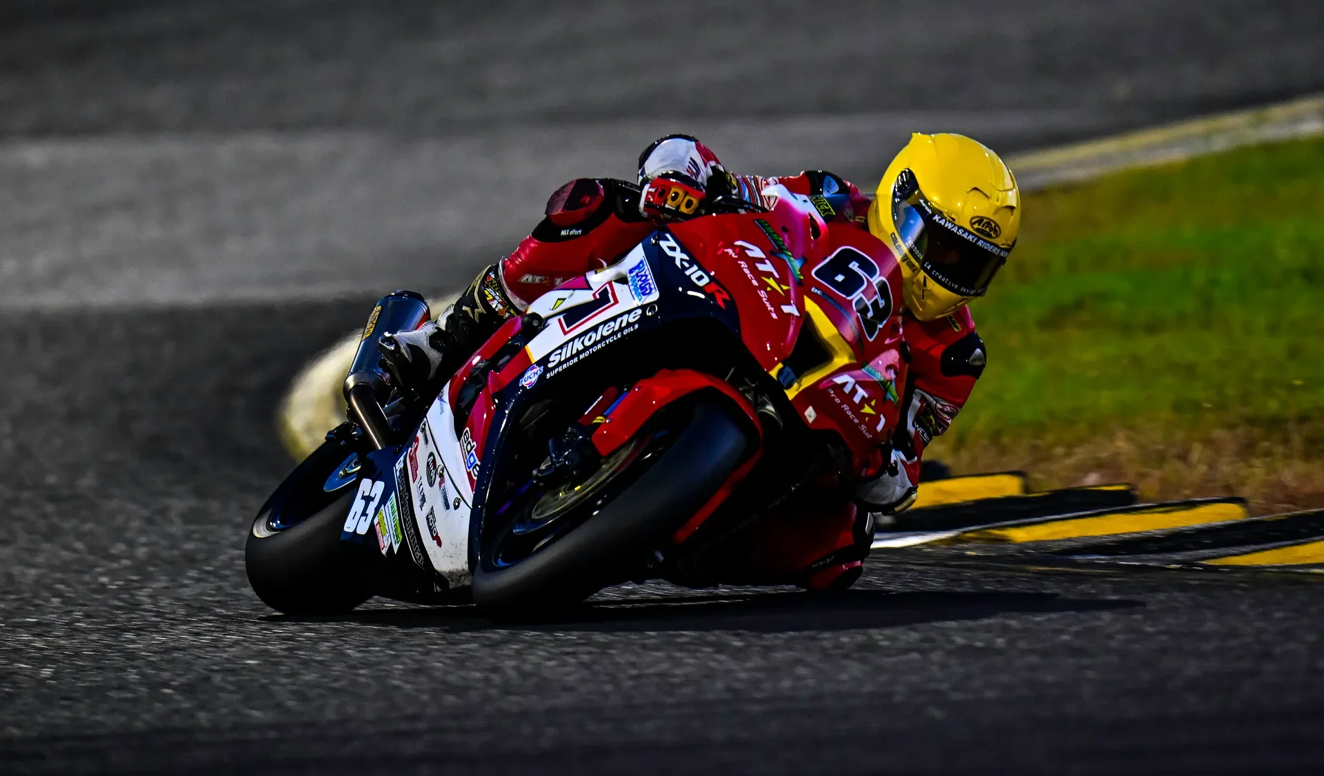 AT1 Pro Racing rider at full lean in a custom race suit