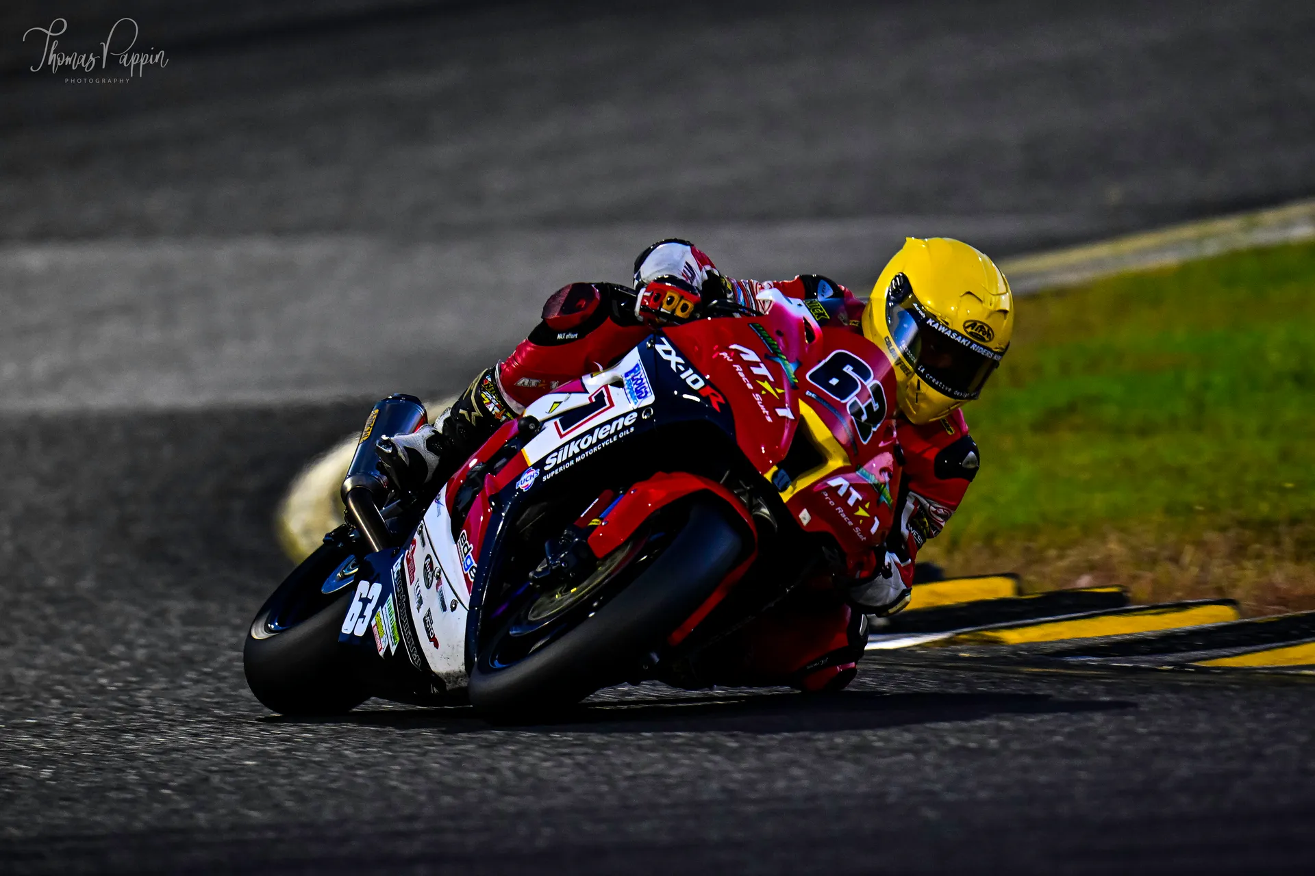 AT1 Pro Racing rider at full lean in a custom race suit