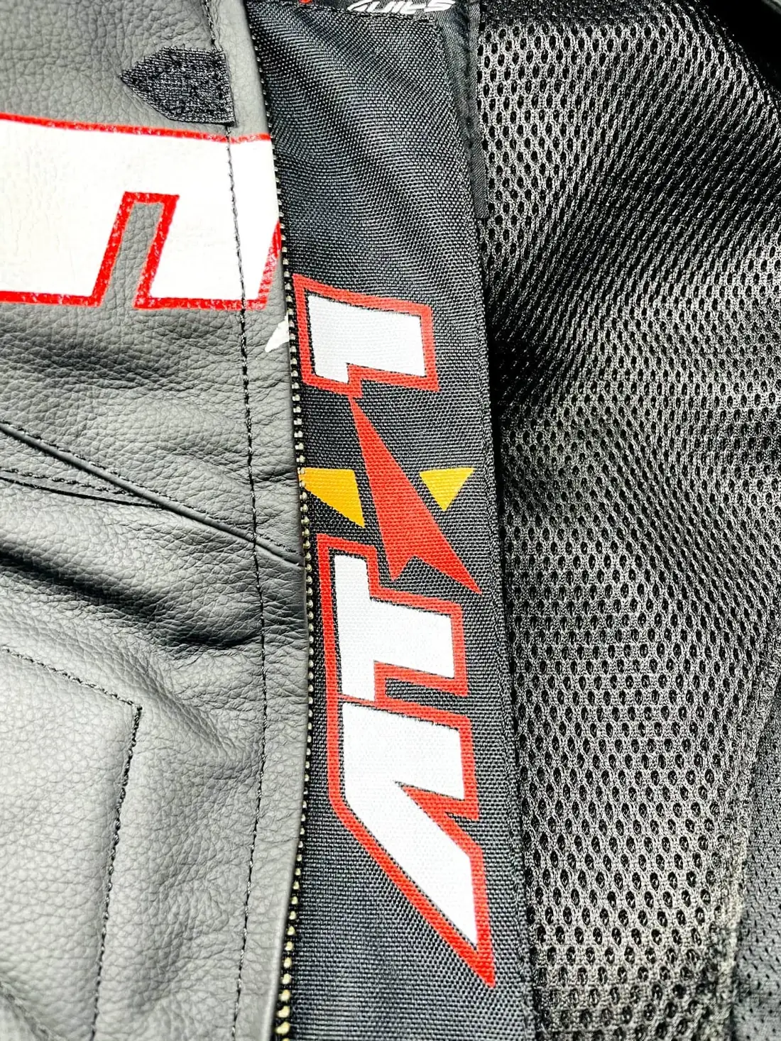 Close-up of kangaroo leather perforation and safety stitching on an AT1 suit