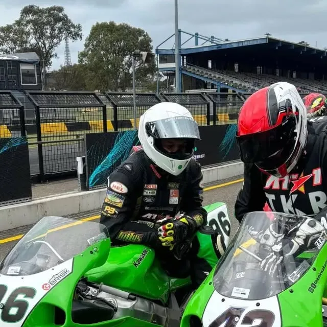 Team Kawaka Racing rider and crew in pit lane wearing AT1 leathers